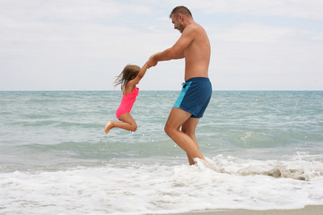 Fototapeta premium Family at the beach in the summertime.