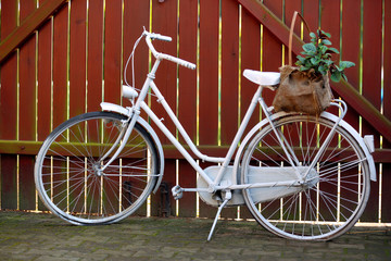 Fototapeta na wymiar White bicycle on a wooden fence background