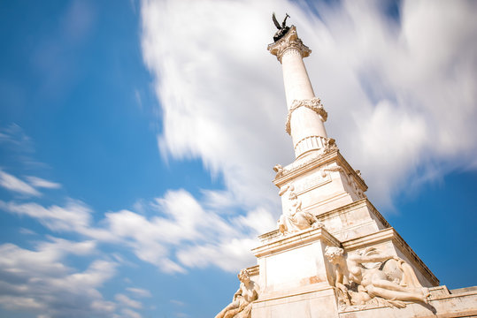 View from below on the Girondins column in Bordeaux city in France. Long exposure image technic with motion blurred clouds