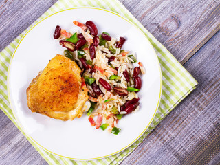 Chicken with Rice, Beans, Bacon and Green Pepper on White Plate. View from above, top studio shot