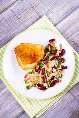 Chicken with Rice, Beans, Bacon and Green Pepper on White Plate. View from above, top studio shot