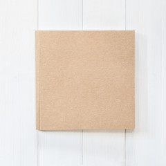 Fototapeta premium Blank book mock up square-size catalog magazines, brochure or note cover template recycle brown paper texture flat lay on white color wood table from top view