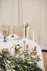 decorated table bride and groom with flasks for candles, flowers, candles and candlesticks and number of the table