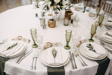 decorated table bride and groom with flasks for candles, flowers, candles and candlesticks and number of the table