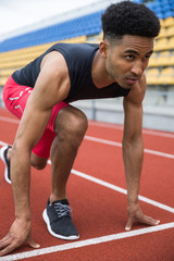 Concentrated african athlete man ready to start