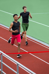 Group of athlete men run on running track outdoors