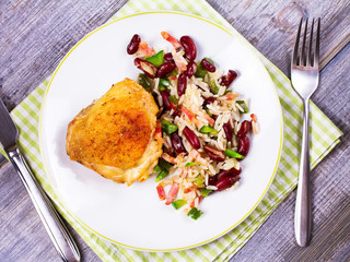 Chicken with Rice, Beans, Bacon and Green Pepper on White Plate. View from above, top studio shot
