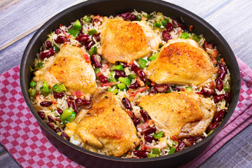 Chicken with Rice, Beans, Bacon and Green Pepper in Pan. View from above, top studio shot