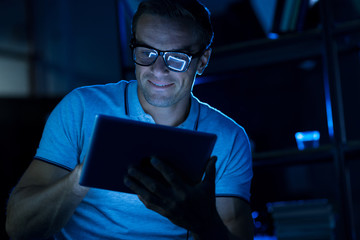 Creative handsome man using his gadget at night
