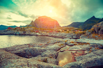 Rocky seashore with cloudy sky at sunset. Beautiful nature of Norway. Lofoten islands. Reine