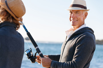Senior man fishing with his grandson to fish at sea
