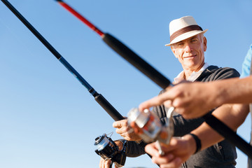 Obraz premium Senior man fishing at sea side