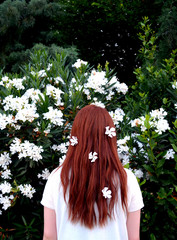Naklejka premium Young redhead girl with white flowers in her hair.