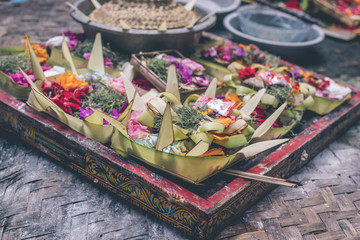 Traditional balinese offerings to gods in Bali with flowers and aromatic sticks. Bali island.