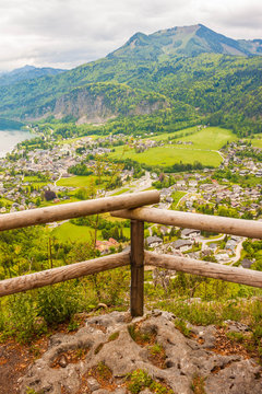 Viewpoint on Plomberg mountain with wooden fence. Beautiful high up view of alpine village St. Gilgen and Zwolferhorn mountain. Austria