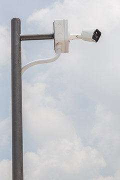 Security camera, CCTV is installed for monitoring on building with blurred blue sky in background\