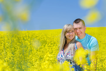 Happy couple in yellow rape field.