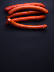 Red sausages from Denmark made from pork meat, often used for hot dogs or eaten with hot dog bread. Isolated on black background 