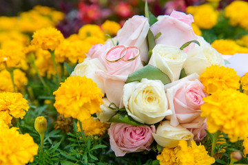 Wedding rings on wedding bouquet in flowers
