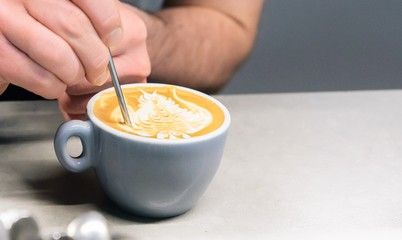 Close up of barista making an owl on cappuccino froth, isolated