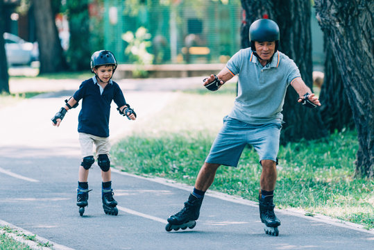Grandfather teaching grandson roller skating in the park