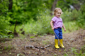 The little lovely girl walks on the wood.