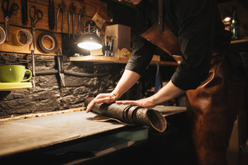 Young concentrated man shoemaker