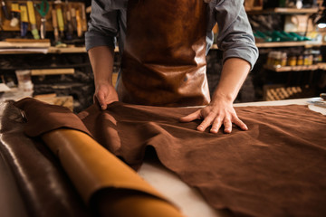 Close up of a cobbler working with leather textile - Powered by Adobe