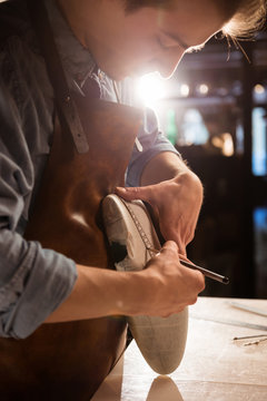 Close up of a cobbler doing measurments for a shoe
