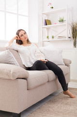 Obraz premium Young thoughtful woman with smartphone