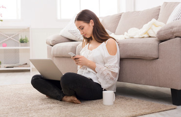 Girl with a laptop messaging on mobile