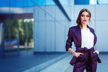 Young woman posing in purple suit. Fashion makeup