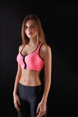 Beautiful fitness girl posing on black background