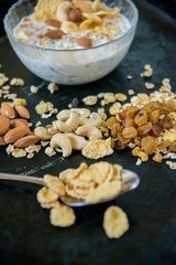 Healthy breakfast. Fresh granola, muesli with berries, honey in a glass jar on a black slate background.