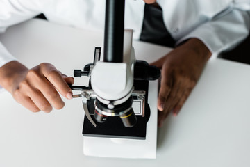 Cropped shot of professional chemist working with microscope in laboratory