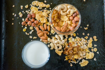 Healthy breakfast. Fresh granola, muesli with berries, honey in a glass jar on a black slate background.