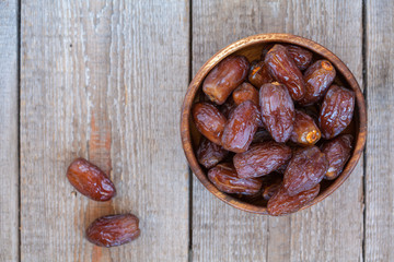 Fresh royal medjool dates in wooden bowl. Love for a healthy vegan food concept.