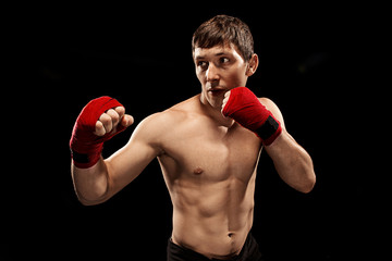 Fototapeta na wymiar Male boxer boxing in punching bag with dramatic edgy lighting in a dark studio