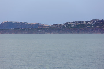 Fototapeta premium Santorini catching the last sunrays with blue haze over the sea