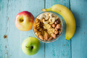 Homemade granola or muesli with oat flakes, dried cranberry, cherry, apricots, goji berries, toasted almonds and peanuts in a jar for breakfast or healthy snack, selective focus