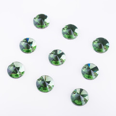 Precious stones of green color of round shape on a white background.