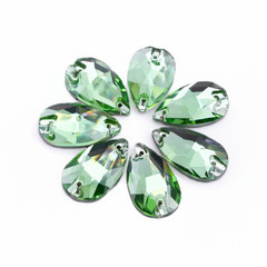 Fototapeta premium Precious stones green color in the shape a tear drop on a white background.