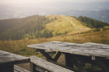 Fototapeta premium Wooden table against mountains, background