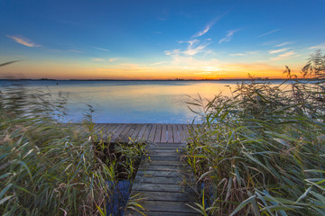 Long Exposure Image of Sunset over Boardwalk on the shore of a Lake