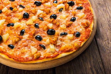 Delicious pizza with pineapples and black olives