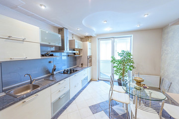 White apartment interior design kitchen, flower and glass table and stove, modern style furniture in chisinau, buiucani district, moldova