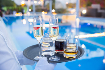 Waiter served champagne glasses on a tray in a fine dining restaurant