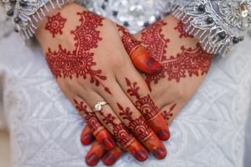 Two female hands with the image of mehendi henna patterns. Beautiful composition on light beige...