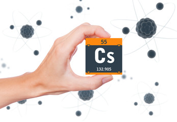 Caesium element symbol handheld and atoms floating in background