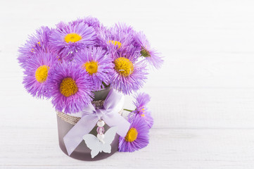 Purple daisies on white table